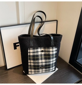 Close-up of black fuzzy tote bag with checkered pocket and leather shoulder straps