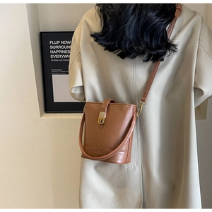 Vue arrière du mannequin portant un sac seau vintage en cuir PU marron à fermoir rotatif