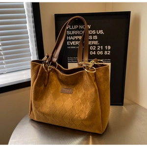 Close-up of brown quilted tote bag showing matte texture and fashion leather label