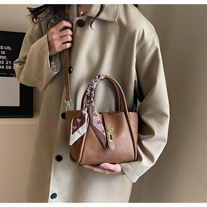 Detail of vintage brown bucket bag with lychee texture leather and a heart pattern silk scarf