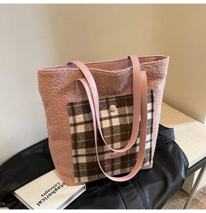 Close-up of pink plush tote bag featuring a checkered pocket and leather handles