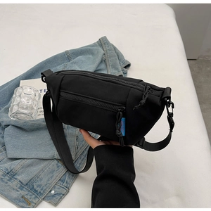 Detailaufnahme der schwarzen Canvas-Umhängetasche mit blauem Label und Funktions-Zipper