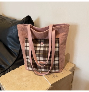 Close-up of pink faux shearling tote bag featuring a plaid pocket and leather strap