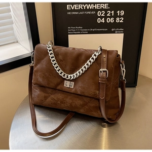 Détail du sac à chaîne marron vintage avec surpiqûres losanges et fermoir métallique
