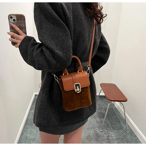 Detail of vintage matte brown crossbody bag with metal buckle and shoulder strap