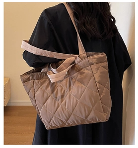 Detail of quilted nylon tote bag in metallic dark brown with padded shoulder strap