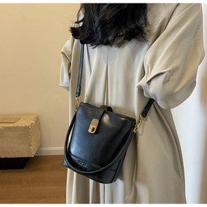 Détail du sac seau en cuir noir avec logo XICH et bandoulière réglable pratique