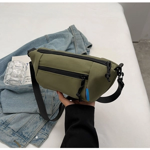 Detailansicht der olivgrünen Nylon-Umhängetasche mit blauem Canvas Bag Webetikett