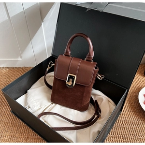 Detailed close-up of brown vintage square handbag with matte finish and gold metal clasp
