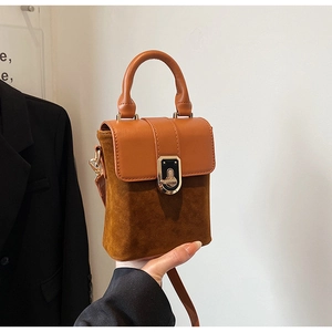 Detail of vintage crossbody bag with frosted texture and rotating golden metal lock