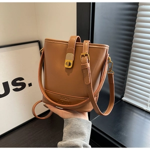 Vue détaillée du sac seau marron avec boucle en métal doré et sangle de main