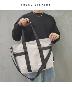 Detail view of large nylon tote bag featuring black reinforced straps and buckle