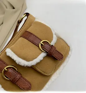 Detail der braunen Wildledertasche mit Lammfellbesatz und Krokodilleder-Riemen am Rand