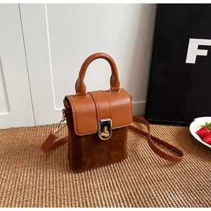 Detail showing the brown faux leather and frosted suede texture with gold metal buckle