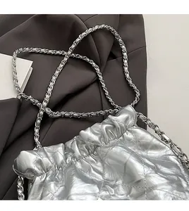 Detailed macro of silver metallic quilted bag showing texture and chain strap