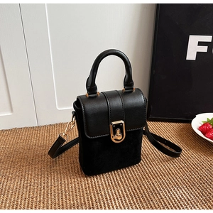 Detail of black retro mini crossbody bag with gold hardware and textured leather finish