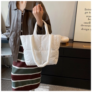 Détail macro du sac cabas matelassé blanc texturé en duvet avec anses souples