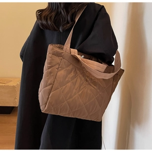 Detail of large quilted nylon tote bag in coffee brown with classic diamond stitching