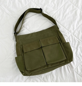 Dettaglio della borsa a tracolla in tela verde militare con grandi tasche e tracolla regolabile