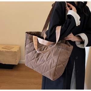 Detail of a light brown quilted nylon tote bag with high-density diamond stitching