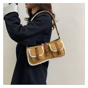 Seitenansicht der braunen Vintage-Tasche mit weißem Kunstlammfell und Schnallen-Details