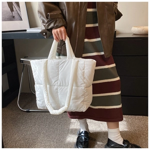 Sac cabas en nylon blanc matelassé avec poignées et bandoulière dans un intérieur vintage