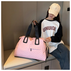 Detalle de bolsa de viaje acolchada rosa con correas negras y gran capacidad de fitness