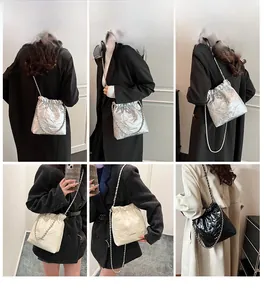Detailed model view showing silver, beige, and black drawstring bucket bags with chain straps