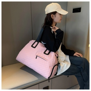 Detalle de bolsa de viaje rosa acolchada con gran capacidad y bolsillos con cremallera