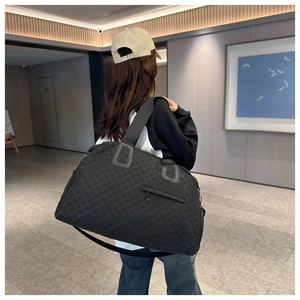 Bolso de viaje acolchado negro llevado al hombro en un entorno de estilo de vida
