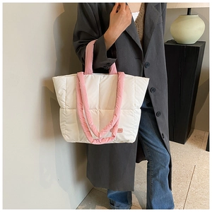 Détail du sac cabas matelassé blanc avec anses roses et petit logo de mode