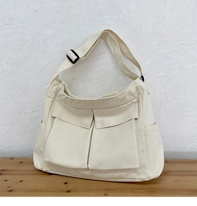 Vista dettagliata della borsa tote in tela bianco crema con tasche anteriori a patta
