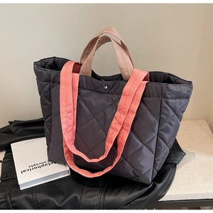Close-up of quilted nylon tote bag with rhombus stitching and dual-color handles