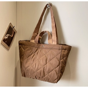 Close-up of brown quilted nylon tote bag featuring diamond patterns and silver metal snap