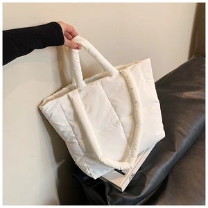 Détail du sac cabas matelassé blanc avec poignées rembourrées douces pour un style d'hiver