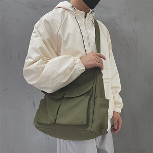 Dettaglio della borsa tote in tela verde militare con ampie tasche e stile vintage