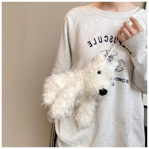 Dettaglio della borsa a tracolla a forma di cucciolo in peluche bianco con texture riccia