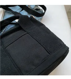 Detail of the high-quality black canvas texture and durable fabric handle on a tote bag