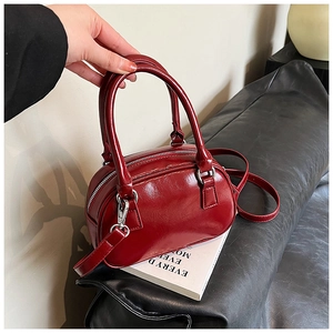 Detail of burgundy glossy leather mini Boston bag with silver hardware and top handles