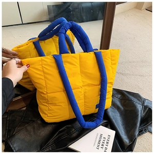Détail du cabas matelassé bicolore bleu et jaune avec des poignées rembourrées
