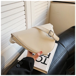 Dettaglio della borsa a tracolla in ecopelle beige con fibbia in metallo e patta