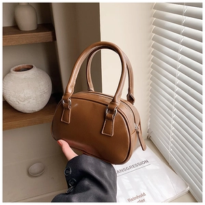 Close-up of brown faux leather Boston bag with silver hardware and smooth texture