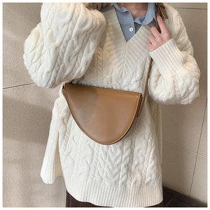 Dettaglio della borsa a sella minimalista in pelle marrone con tracolla regolabile
