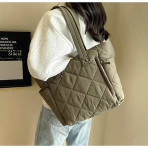 Detailed shot of olive green quilted nylon tote bag with high-quality stitching texture