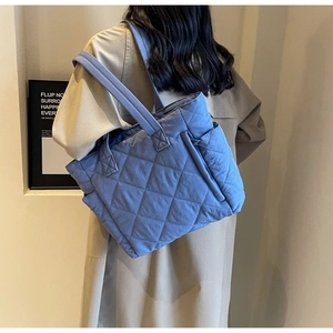 Detailed macro view of the blue quilted rhombic pattern on a large nylon tote bag