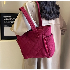 Close-up of wine red quilted nylon tote bag with side zipper and diamond pattern