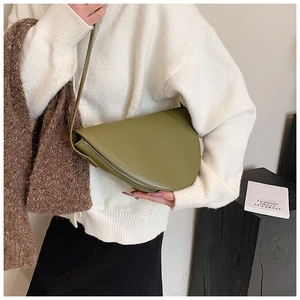 Borsa a tracolla a mezzaluna verde oliva in finta pelle liscia indossata su maglia bianca