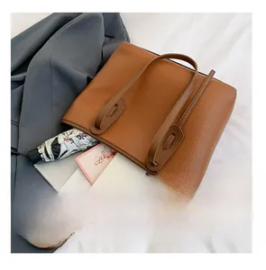Interior view showing the large capacity of the brown leather tote bag with tech items