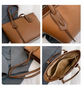 Detail view of caramel tote bag featuring pebble leather texture and zip pockets