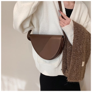 Borsa a tracolla a mezzaluna marrone scuro abbinata a cardigan bianco in maglia